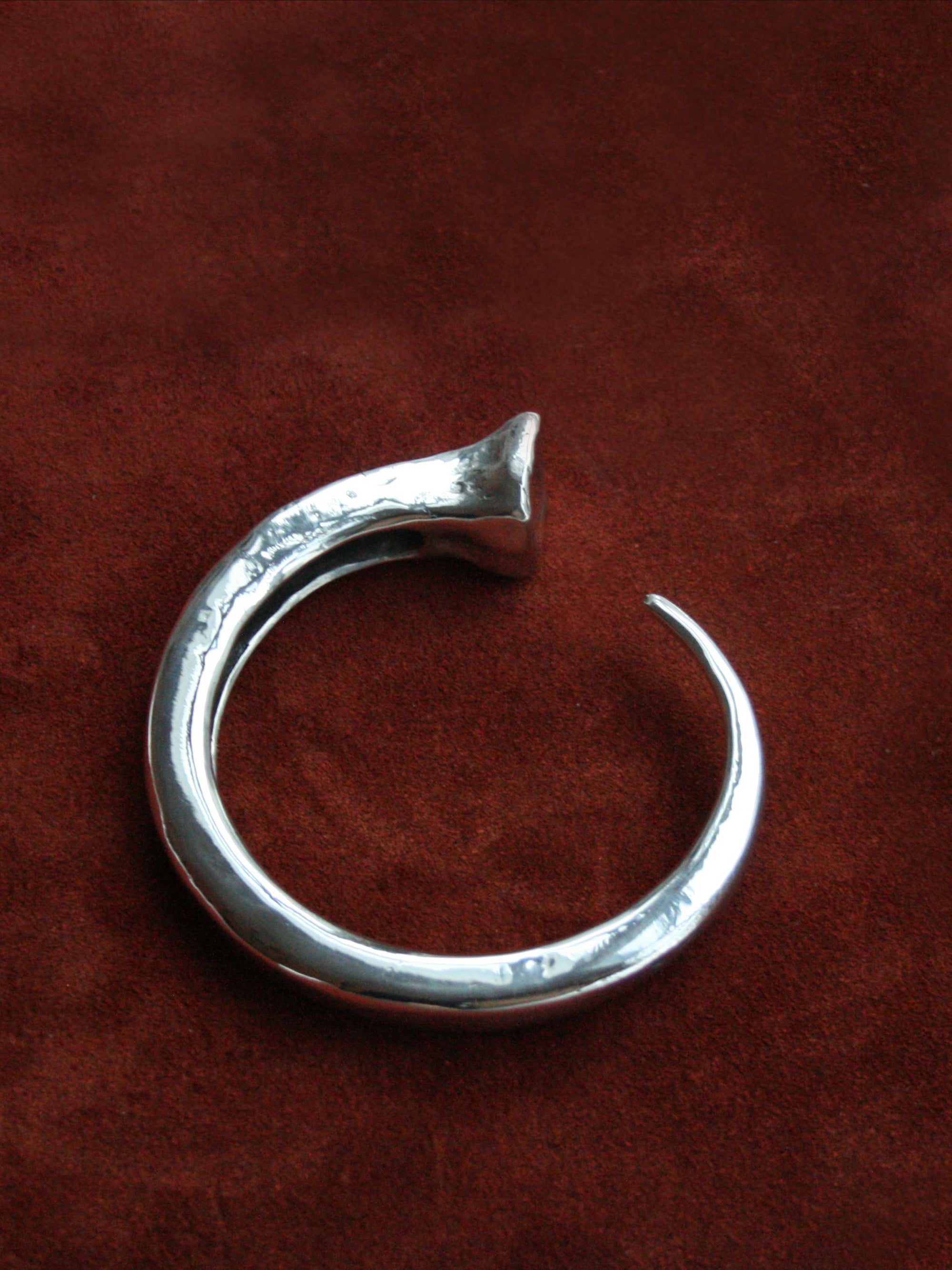Sterling silver nail bracelet against brown leather