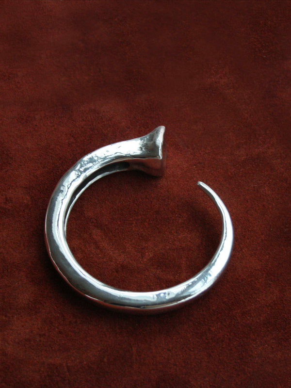 Sterling silver nail bracelet against brown leather